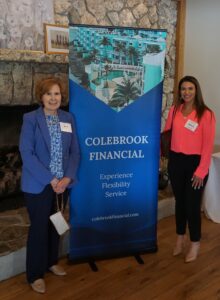 Beth D’Amato of Dime Bank and Melissa Bierowka of Chelsea Groton Bank frame the Colebrook banner before the start of the seminar.