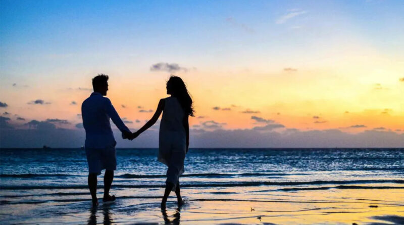Young couple enjoying a walk on the beach.