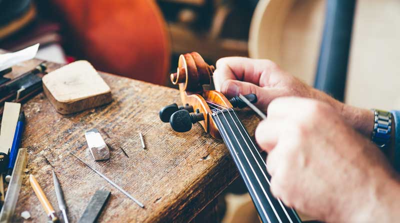 Luthier repair violin in his workshop